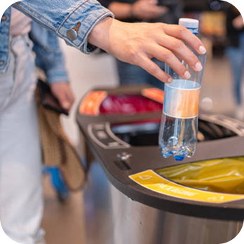 Somebody recycling a plastic drinks bottle